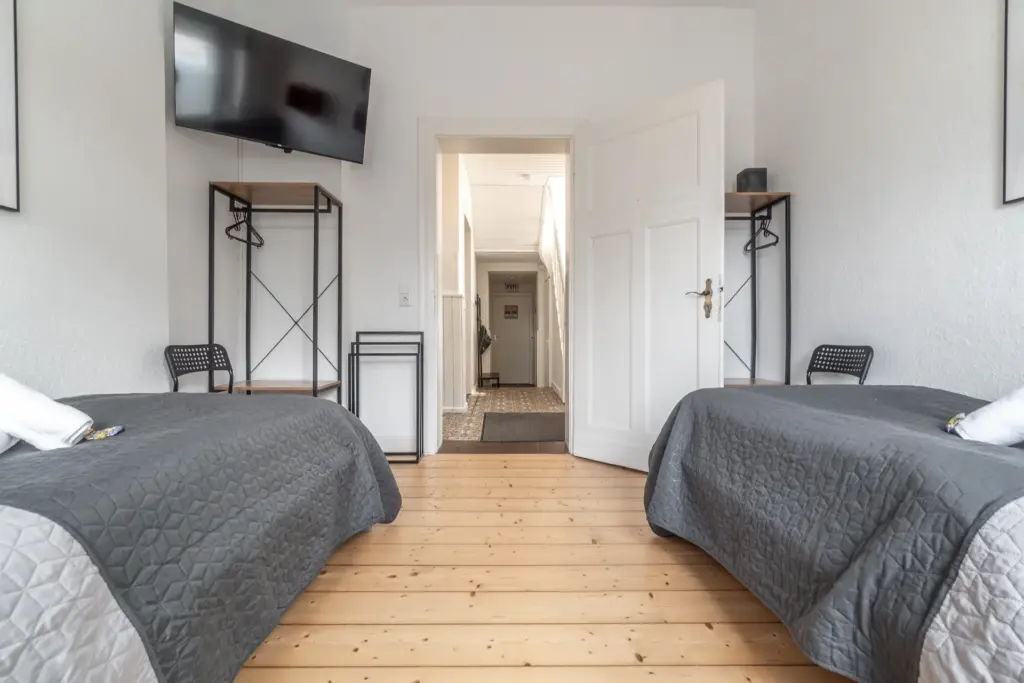 Schlafzimmer, Schlafen, Betten, Einzelbett, Tageslicht, Fenster, Nachttisch, Bettwäsche, Smart-TV, TV, Fernseher, Kleiderständer